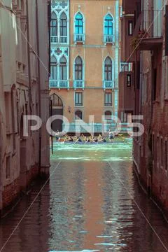 View of rowing boat team in canal between building Stock Photos