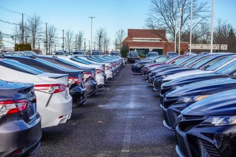 View of rows of various colored new cars in a parking lot  Stock Photos