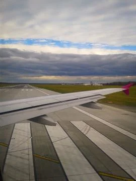 View Of The Runway And The Wing Of The Plane Through The Porthole Stock Photos