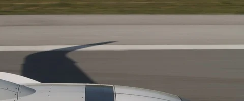 View of the runway during plane's take off with the shadow of the wing. Stock Footage 127135610
