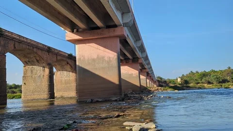 View from rural bridge over natural waterway under bright blue sky in count.. 스톡 동영상 334792989
