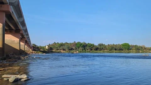 View from rural bridge over natural waterway under bright blue sky in count.. Stock Footage 334793209