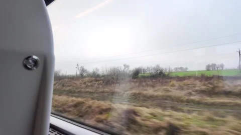 View of rural countryside passing by a train window, showing motion blur and Stockbeeldmateriaal 345669699