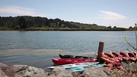 View of Russian River with kayaks at dock with gentle waves and slight breeze Video stock 79549854