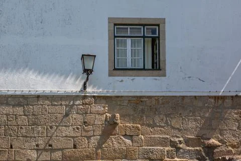 View of a rustic facade building with a window and a retro public street lamp Foto stock