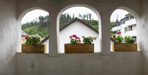 View from a rustic white plaster balcony through three open stone arches de.. Stock Photos
