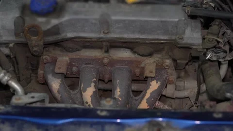 View of a rusty four-cylinder car engine exhaust manifold assembly. Stock Footage 345913314