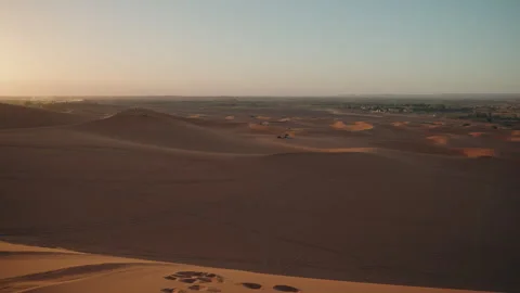 View from Sahara dune top over Erg Chebbi at sunset with footprints and Stock Footage 334512388