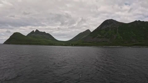 View sailing towards open sea past dramatic mountain saddle gap in Gryllefjord 库存影片 342755844