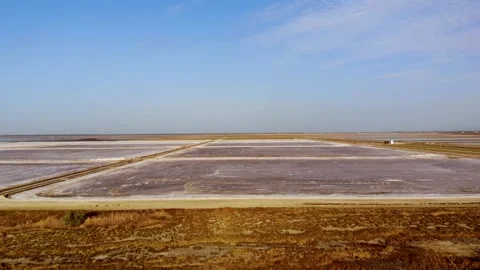 View of a salt flat factory besides the sea - Drone Shot of salt extraction Stock Footage 253282138