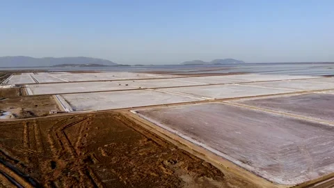 View of a salt flat factory besides the sea - Drone Shot of salt extraction Stock Footage 253282362