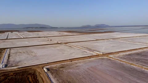 View of a salt flat factory besides the sea - Drone Shot of salt extraction Stock Footage 253282845