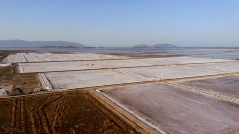 View of a salt flat factory besides the sea - Drone Shot of salt extraction Stock Footage 253282891
