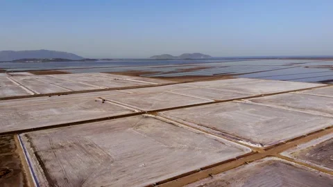View of a salt flat factory besides the sea - Drone Shot of salt extraction Stock Footage 268551630