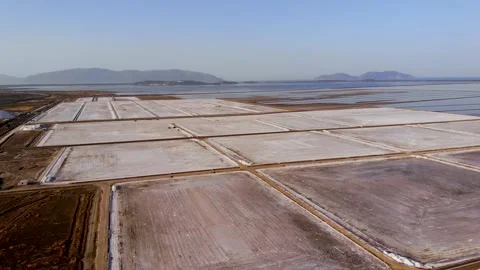 View of a salt flat factory besides the sea - Drone Shot of salt extraction Stock Footage 268881944