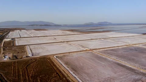 View of a salt flat factory besides the sea - Drone Shot of salt extraction Stock Footage 268882348