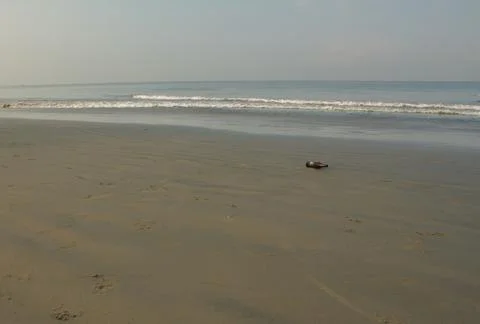 View from the sandy beach with a bottle in the foreground Stock Photos