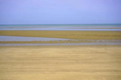 View of a sandy beach during the day with a blue sky background Stock Photos