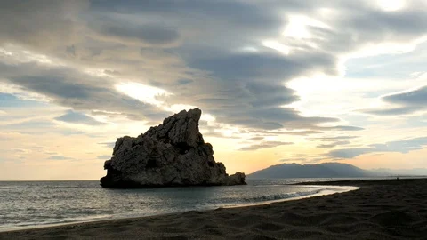 View of a sandy beach during sunset with a big nice rock and dramatic sky. Stock Footage 119119268