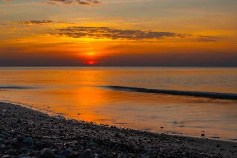 View of sandy beach with pebbles of Baltic Sea on Curonian Spit at sunset. Ka Stock Photos