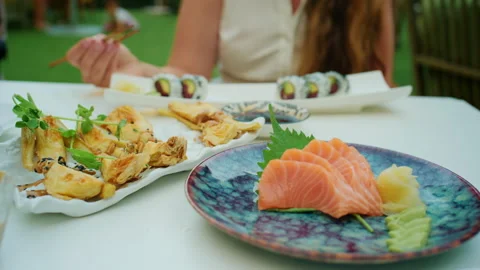View of a sashimi and sushi spread with fried appetizers and soy sauce on an Stock Footage 344794119