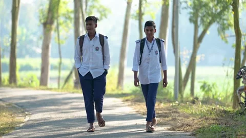 View of schoolboys walking on a rural road in Bogura, Bangladesh. Video stock 335585309
