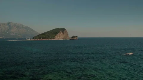 View of sea with boat on background of cliff and mountains on horizon. Stock Footage 82238423