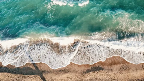 View of sea coast from the top. Rough sea, waves with foam. Camera moving along Stock Footage 145169173