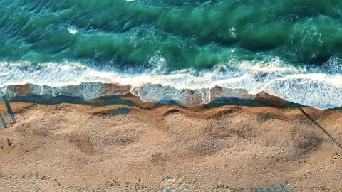 View of sea coast from the top. Waves with foam. Footprints on the beach Stock Footage 145169296