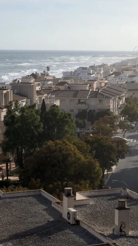 View of sea with high waves and town of Torremolinos, Malaga, Spain. Vertical Stock Footage 240921764