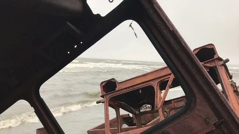 A view of the sea shore through the old destroyed machines. Stock-Footage 80088824