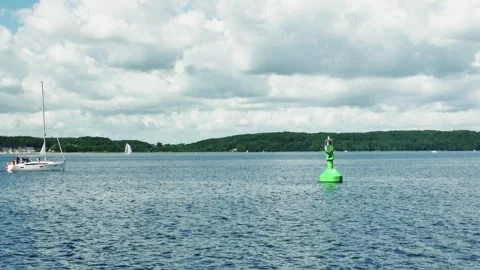View from the sea to the shore with trees, clouds and a floating yacht Stock-Footage 260884223