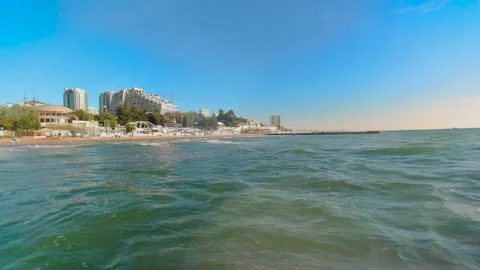 A view of the seashore with waves and sun glare on a bright warm day against the Stock Footage 151079789