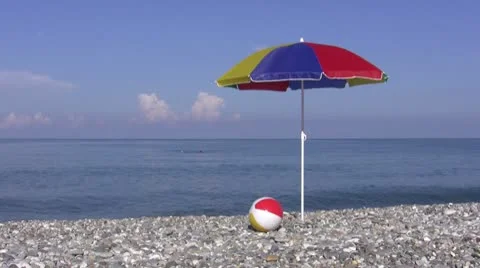 View of seaside and umbrella with ball Stock Footage 9773740