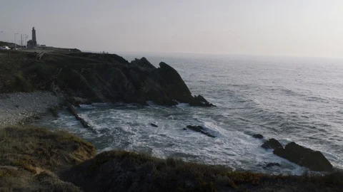 The view of a secluded beach, with a lighthouse far away Video stock 96180878
