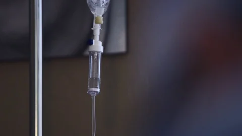 View of the sedation drip from over doctor's shoulder during surgery Stock Footage 113729875