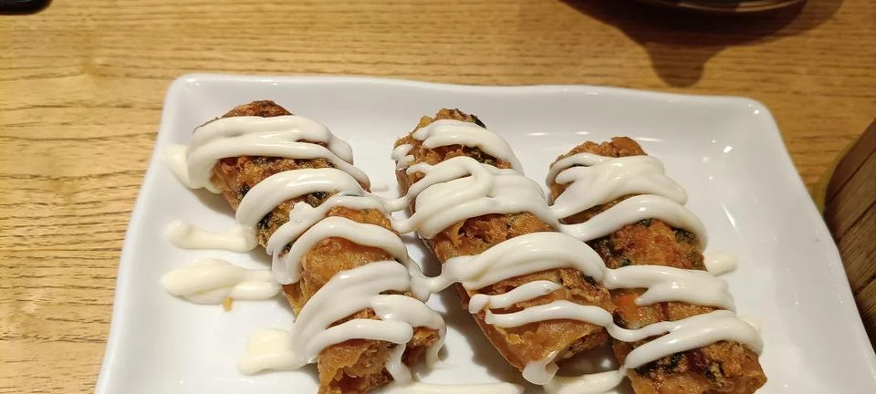 View of a serving of crispy spring rolls on the table Stock Photos