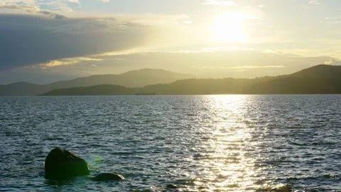 View of the setting sun over the sea horizon from the top a hill Stock Footage 157249518