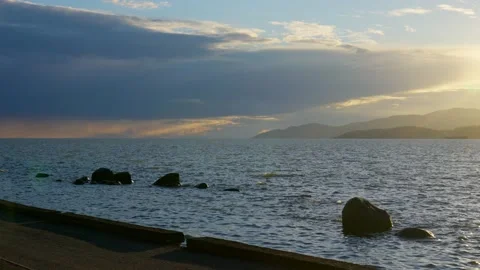 View of the setting sun over the sea horizon from the top a hill Stock Footage 157249606