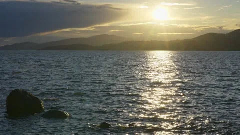 View of the setting sun over the sea horizon from the top a hill Stock Footage 157249924