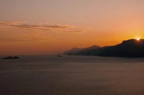 View of the setting sun over the slopes of the mountains Stock Photos