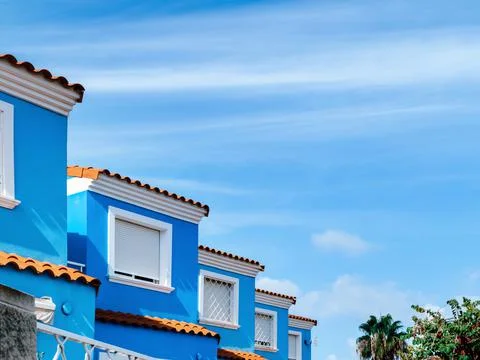 View of several identical windows of a blue townhouses against the background Stock Photos