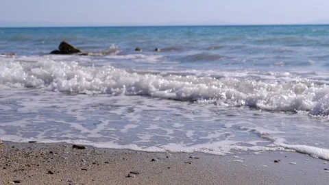 View, Shimmering sea waves gently wash the shore at sunset. Stock Footage 313870095