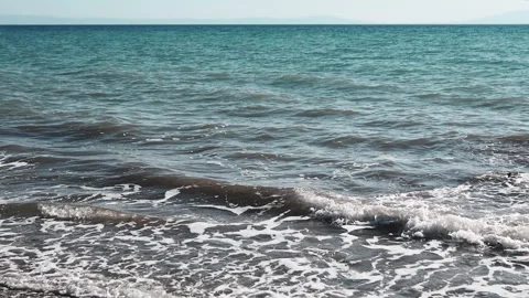 View, Shimmering sea waves gently wash the shore at sunset. Stock Footage 313870361