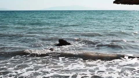 View, Shimmering sea waves gently wash the shore at sunset. Stock Footage 313870371