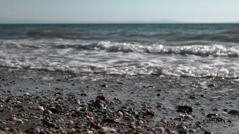 View, Shimmering sea waves gently wash the shore at sunset. Stock Footage 313870561