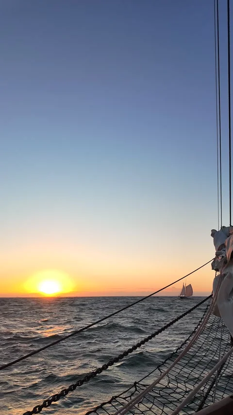 View from ship bow looking at distant schooner at sunset. Stock Footage 342128261