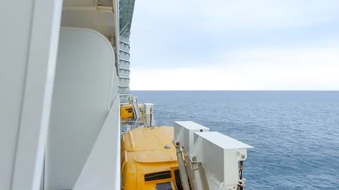 View from ship deck showing yellow machinery against calm ocean and cloudy sky Stock Photos
