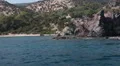 View from ship passing behind rock with mounting on top cross, Latchi, Cyprus HD Footage