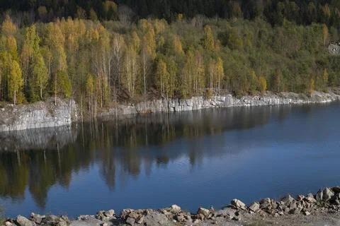 A view of the shore of an old flooded marble quarry in golden autumn. Ruskeala Stock Photos
